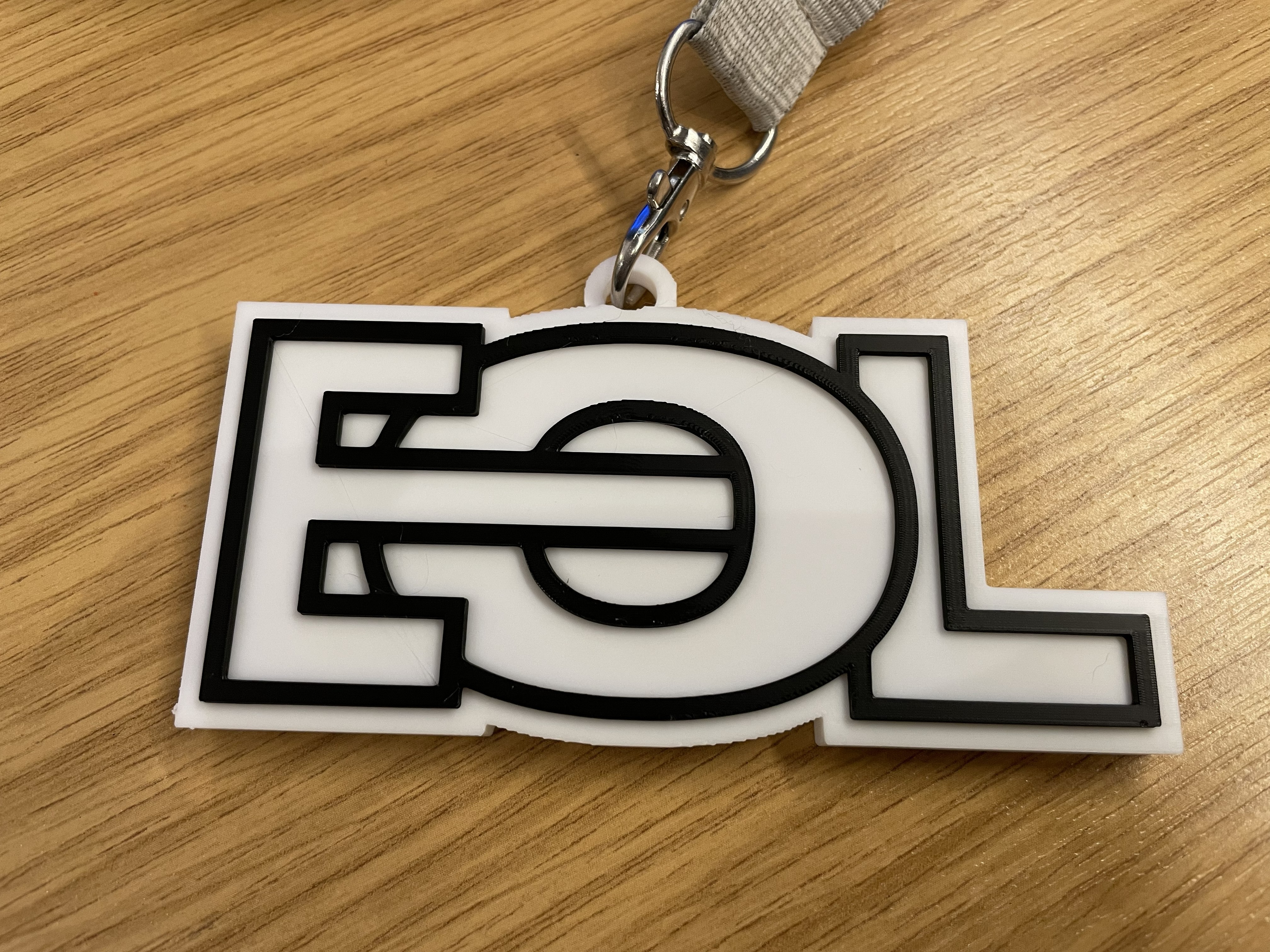 White and black EOL medal on a lanyard