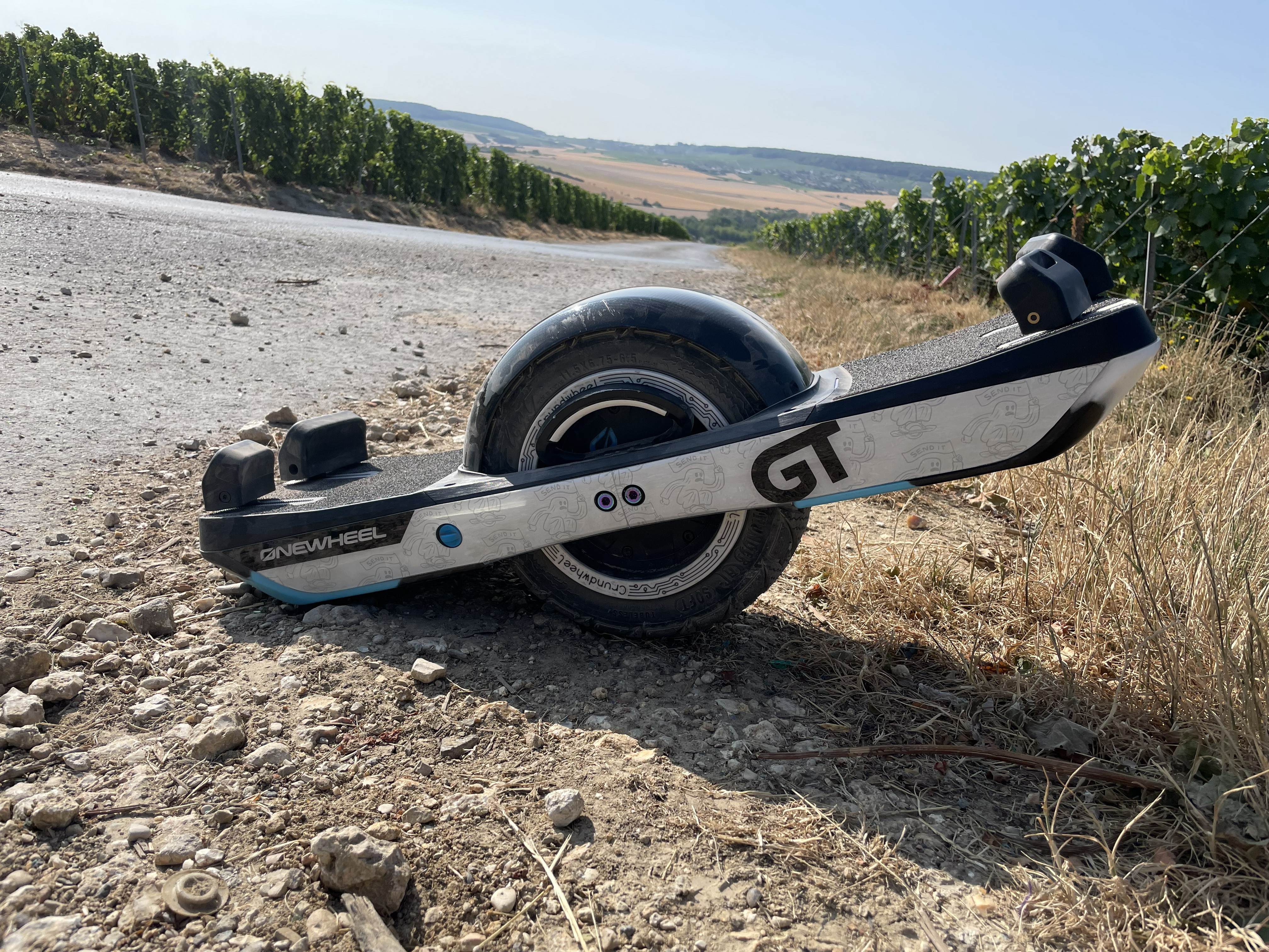 Onewheel GT on a gravel track beside a vineyard